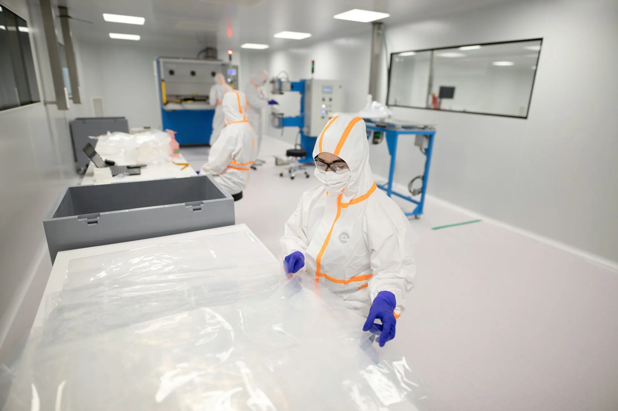 Gowned operator handling sterile film in a cleanroom