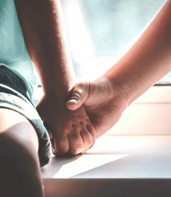 One person holding another person’s hand in support